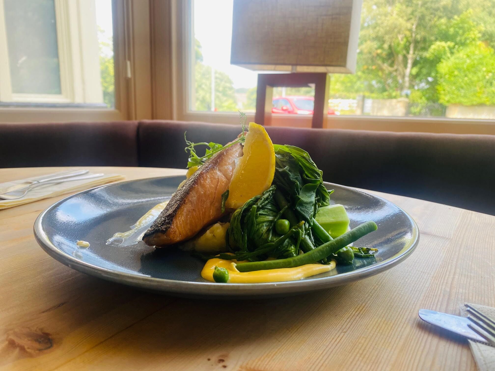 A plate of food on a table with a window view.