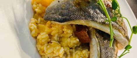 A plate with a fish fillet and rice.