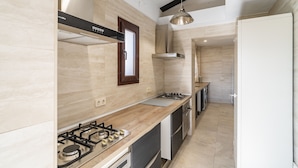 Een moderne keuken met een gasfornuis, een houten aanrechtblad en roestvrijstalen apparatuur.