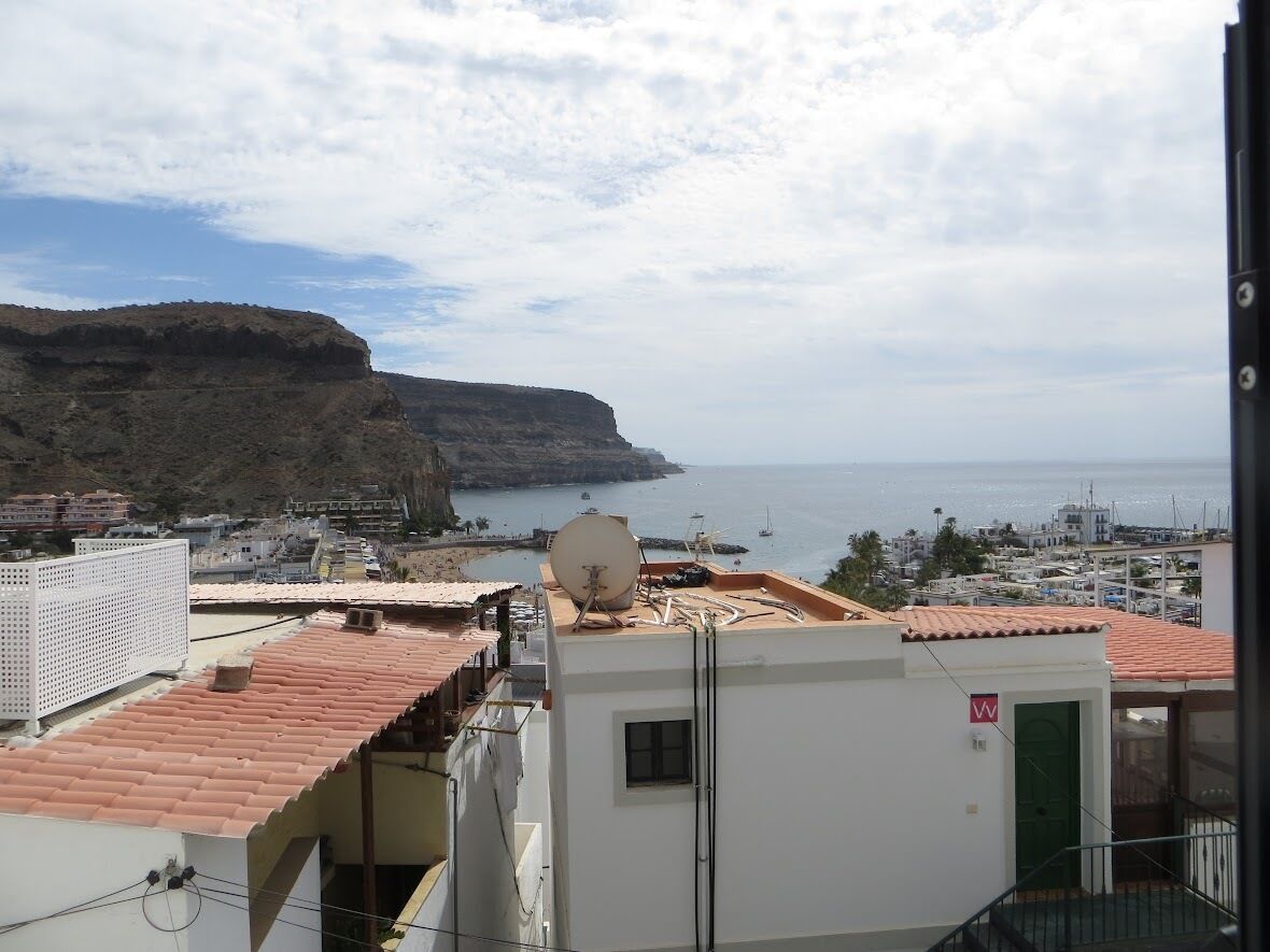 A coastal town with buildings, a cliff, and the sea.