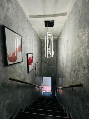 A staircase with a modern design, flanked by walls with a textured finish, leading to an open space. - 1 bedroom apartment with 24h power supply with internet and swimming pool. (Egbeda)