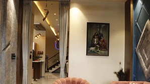 Een modern interieur met een comfortabele fauteuil, een bank, een eethoek en een trap naar een hoger niveau.