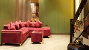 Een moderne woonkamer met een modulaire bank, een poef en een trap.