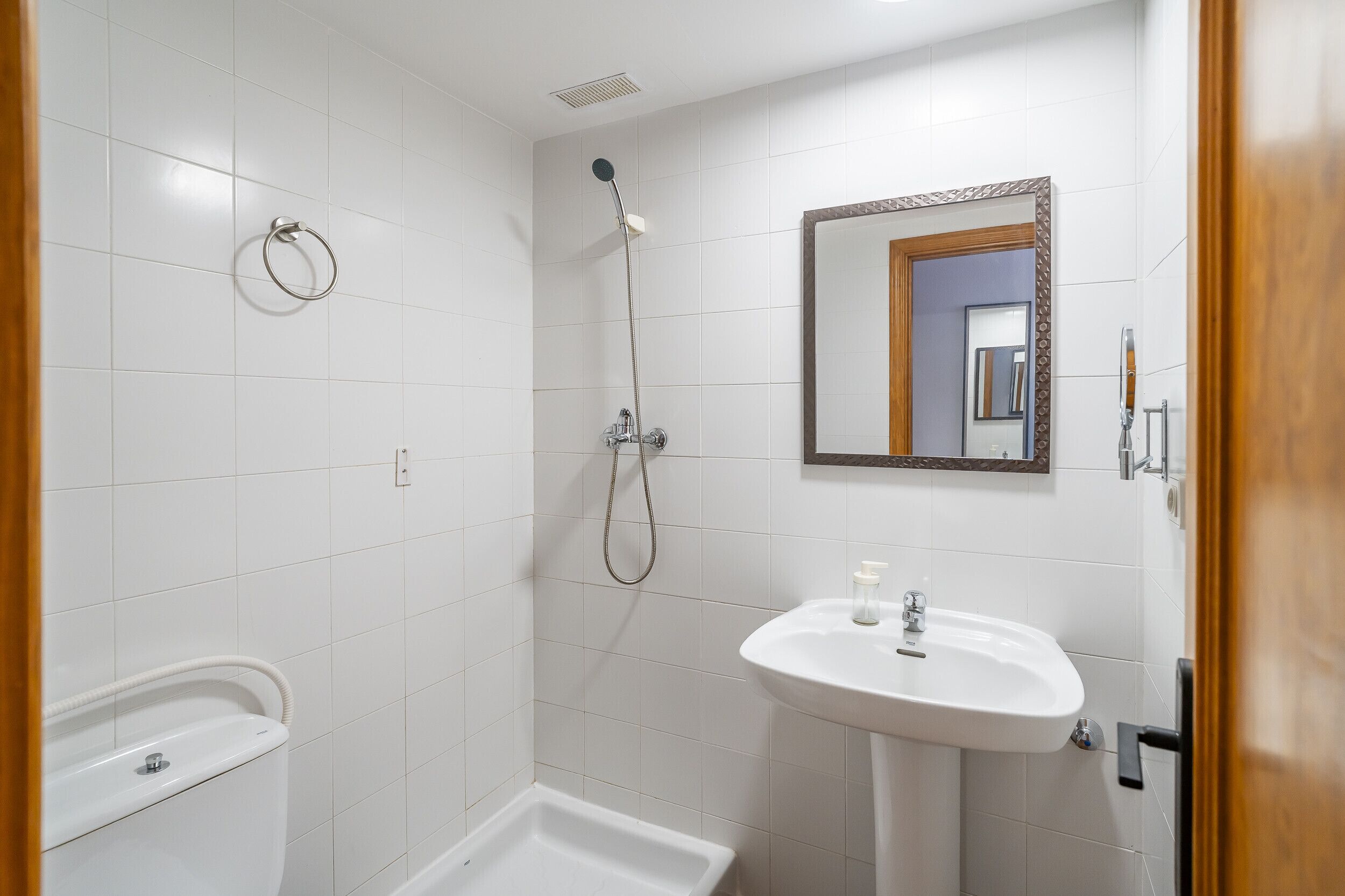 A bathroom with a shower, toilet, and sink.