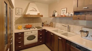 A kitchen with wooden cabinets, a stove, a sink, and a dishwasher. - Sea Horizon Spacious Sea View Villa for Families and Groups (Halkidiki)