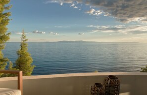 Un balcon avec vue sur la mer et les montagnes au loin.