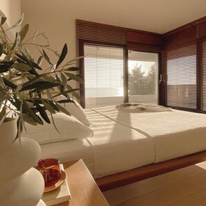 A bedroom with a bed, a plant, and a table with a glass. - Sea Horizon Spacious Sea View Villa for Families and Groups (Halkidiki)