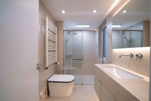 Un bagno moderno con toilette, doccia e lavandino.