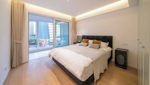 A modern bedroom with a large bed, a small bedside table, a floor lamp, and a view of the city through a sliding door. - Book and Bed-Chang Ning (Shanghai)