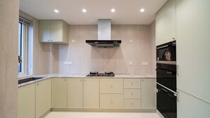 A modern kitchen with a built-in stove, oven, and microwave. - Book and Bed-Chang Ning (Shanghai)
