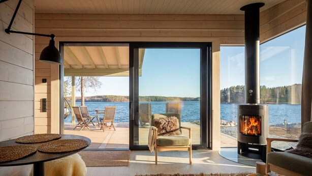 Hyggelig indretning med pejs, spiseplads og udsigt til søen.