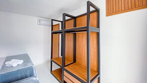 A room with a bunk bed, a wardrobe, and a small table.