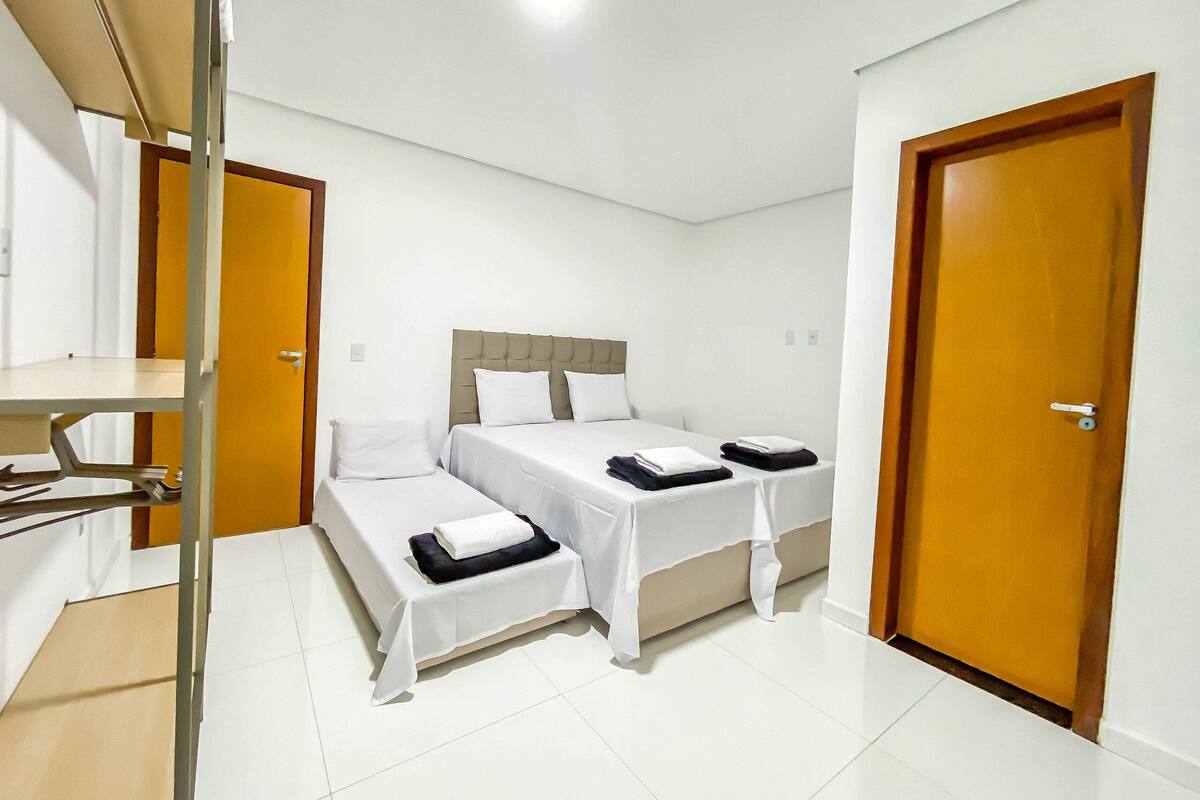 A hotel room with a bed, a desk, and a wardrobe.