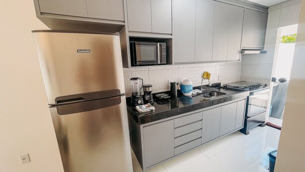 A modern kitchen with stainless steel appliances, a microwave, and a sink.