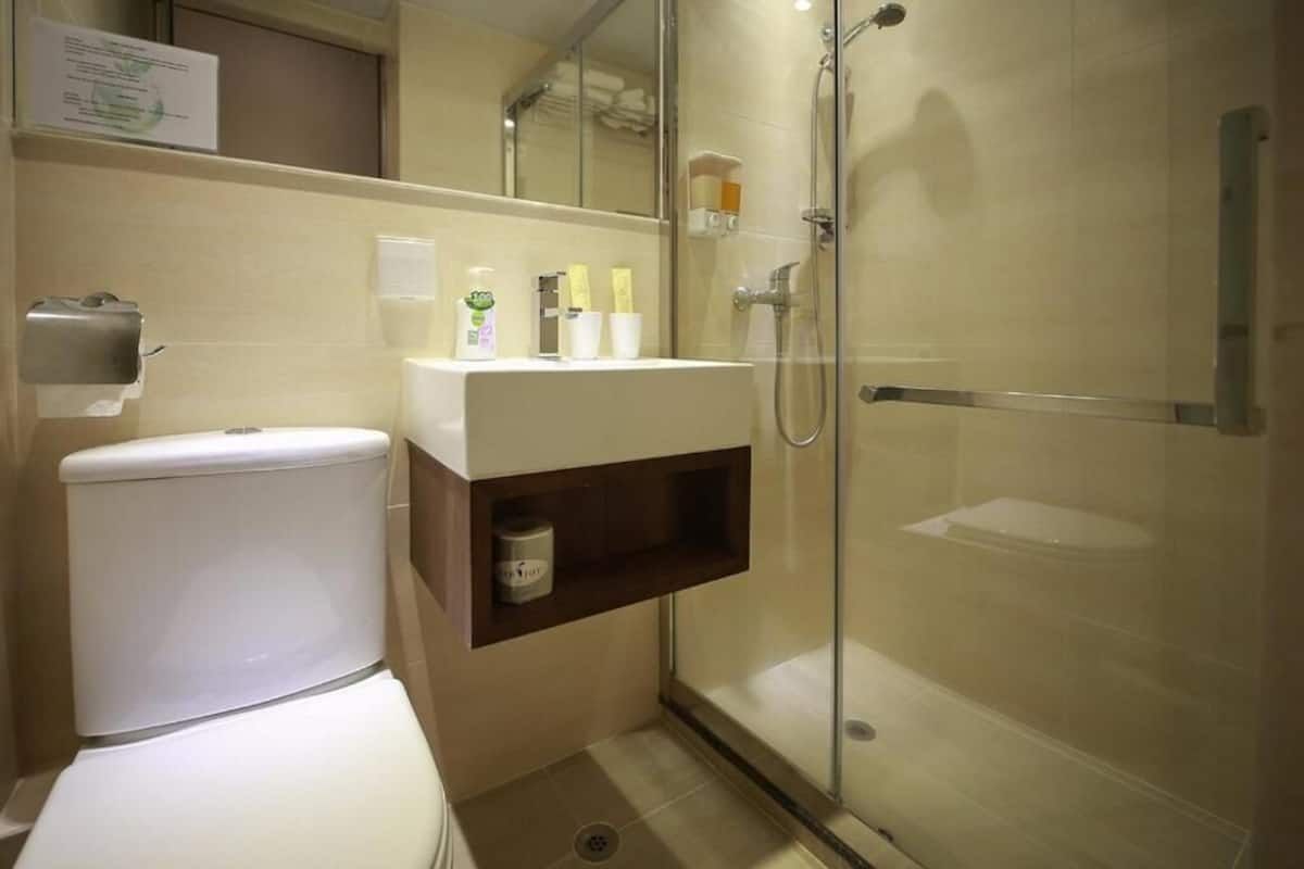 A bathroom with a toilet, sink, and glass-enclosed shower.