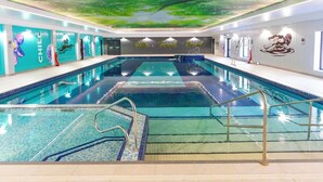 A swimming pool with a green ceiling mural, a lifeguard chair, and a ladder. - Cornish Woodland Retreat (Bodmin)