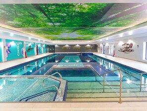 An indoor swimming pool with a ceiling mural, a lifeguard chair, and a ladder. - Cornish Woodland Retreat (Bodmin)