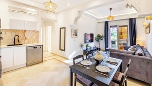 Uma sala de estar moderna com área de jantar, um sofá e uma cozinha com lava-louças.