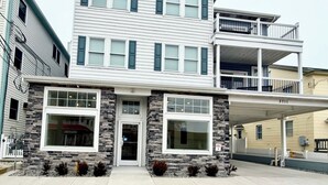 A two-story building with a stone facade, large windows, and a covered entrance area. - Beach Block Downtown Luxury Walk to Everything! (Sea Isle City)