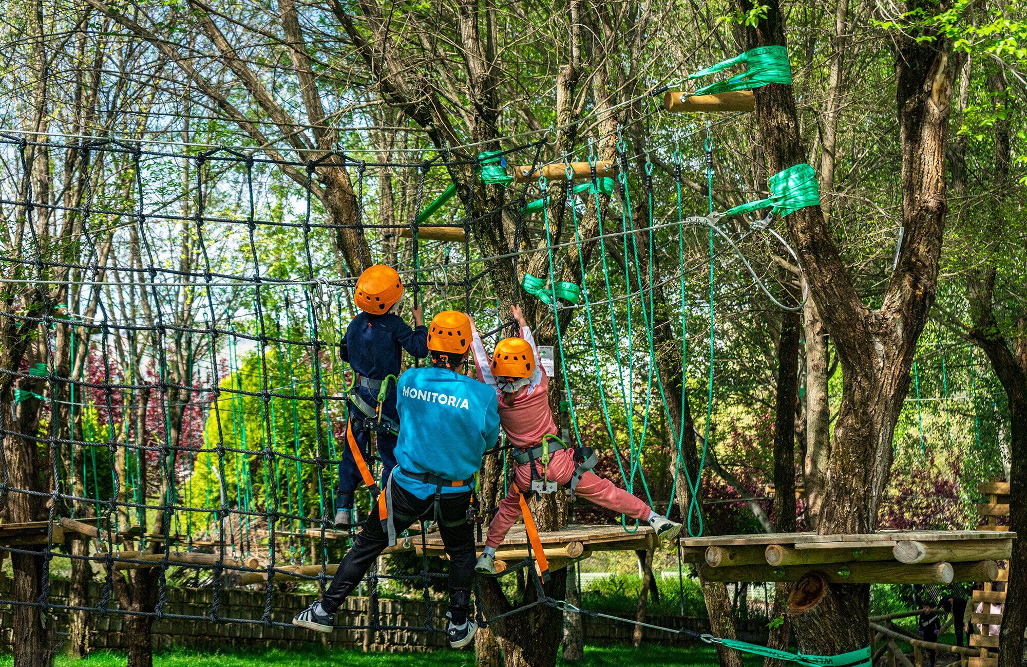 Un circuito de aventura al aire libre con cuerdas y plataformas de madera, rodeado de árboles.