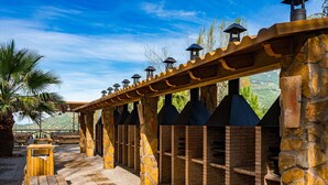 An outdoor seating area with stone pillars and a pergola structure.