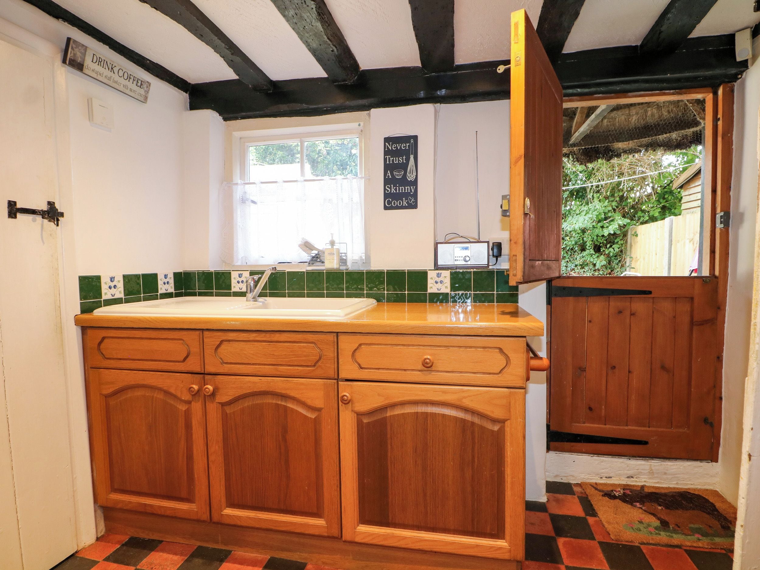 A kitchen with wooden cabinets, a sink, and a window.