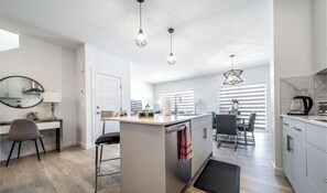 Une cuisine moderne dotée d’un îlot central, d’un coin repas et d’un espace de travail.