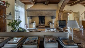 A cozy living room with a fireplace, books, and a lamp.