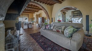 A living room with a sofa, a patterned rug, and an arched ceiling.