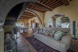 Un soggiorno con divano, tappeto decorato e soffitto a volta.