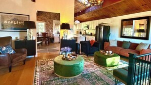 A spacious living area with a high ceiling, a dining area, and a kitchen.