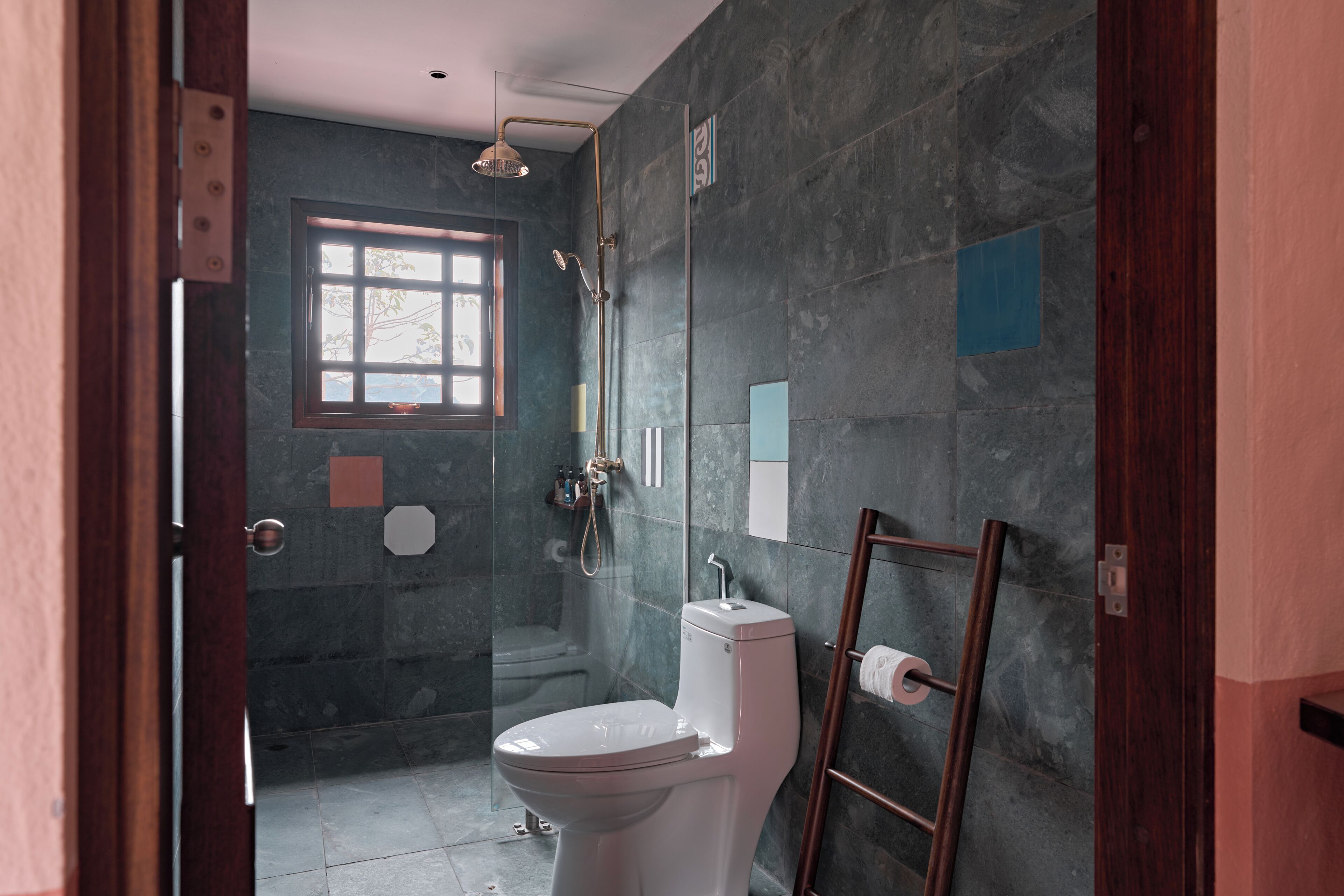 Ein Badezimmer mit Toilette, Dusche, einem Fenster und einem Handtuchhalter.