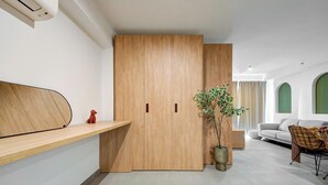 A modern living room with a wooden cabinet, a plant, a sofa, and a chair.