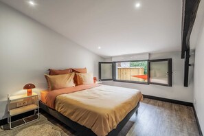 Une chambre à coucher avec un lit, une table de chevet et une fenêtre donnant sur une clôture en bois.