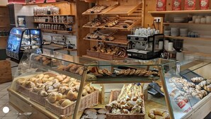 Une vitrine de boulangerie présentant diverses pâtisseries et une machine à café.