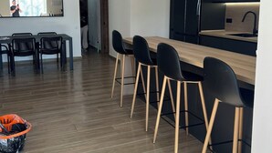 A modern kitchen with a wooden countertop, black chairs, and pendant lights. - Villa Palma Cabo Roig- Spacious 5-bedroom villa in peaceful Cabo Roig with AC (orihueala costa)