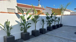 A rooftop terrace with potted plants arranged in a row against a white wall, with a clear blue sky in the background. - Villa Palma Cabo Roig- Spacious 5-bedroom villa in peaceful Cabo Roig with AC (orihueala costa)