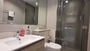 Ein modernes Badezimmer mit Waschbecken, Spiegel und Duschkabine aus Glas.