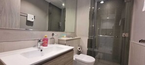 A modern bathroom with a white sink, mirror, and glass shower enclosure. - 1 Bed room-1 sofa bed-Business Bay-Dubai-UAE (Dubai)