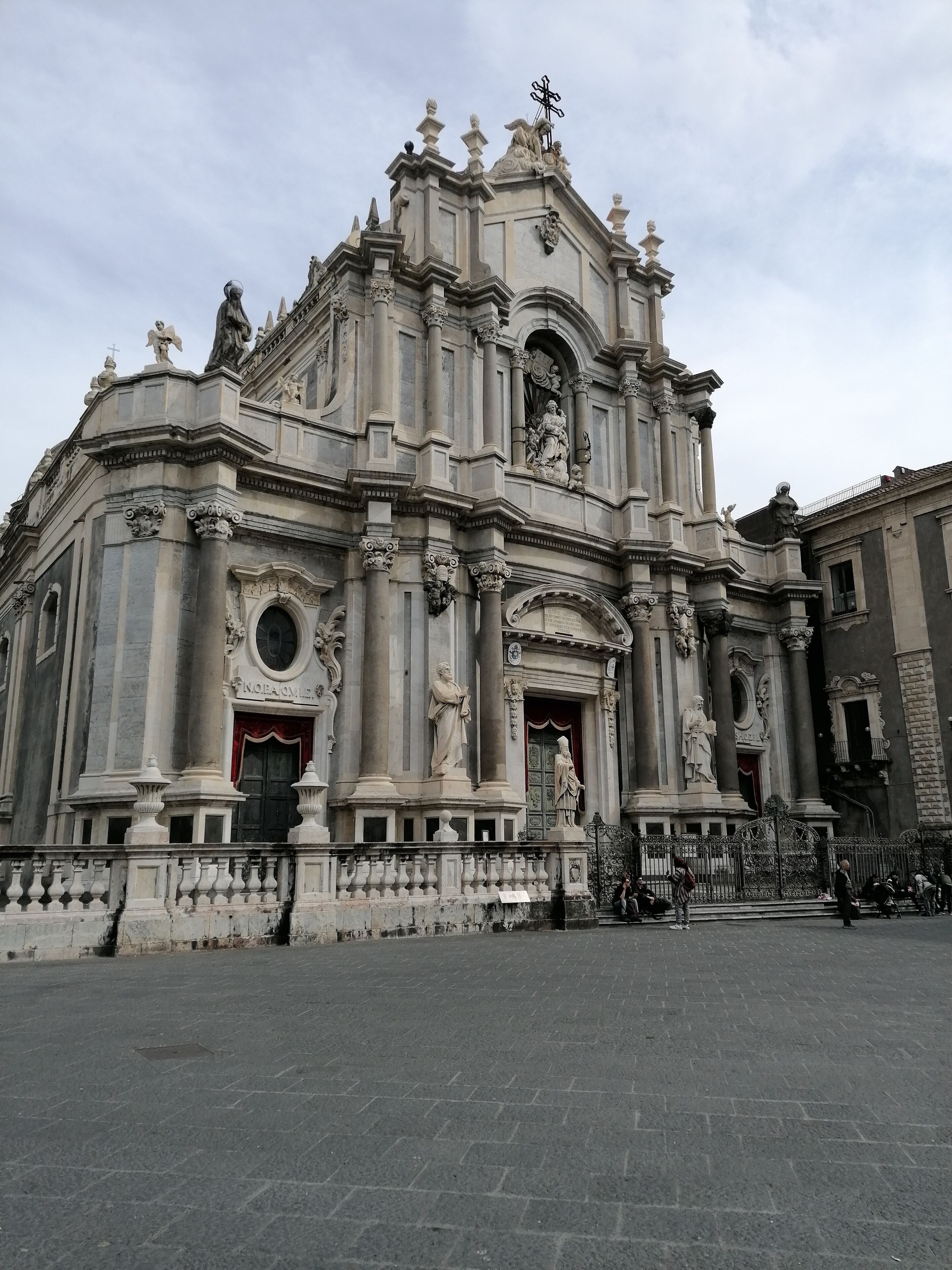 A grand historical building with ornate columns, statues, and a prominent entrance.
