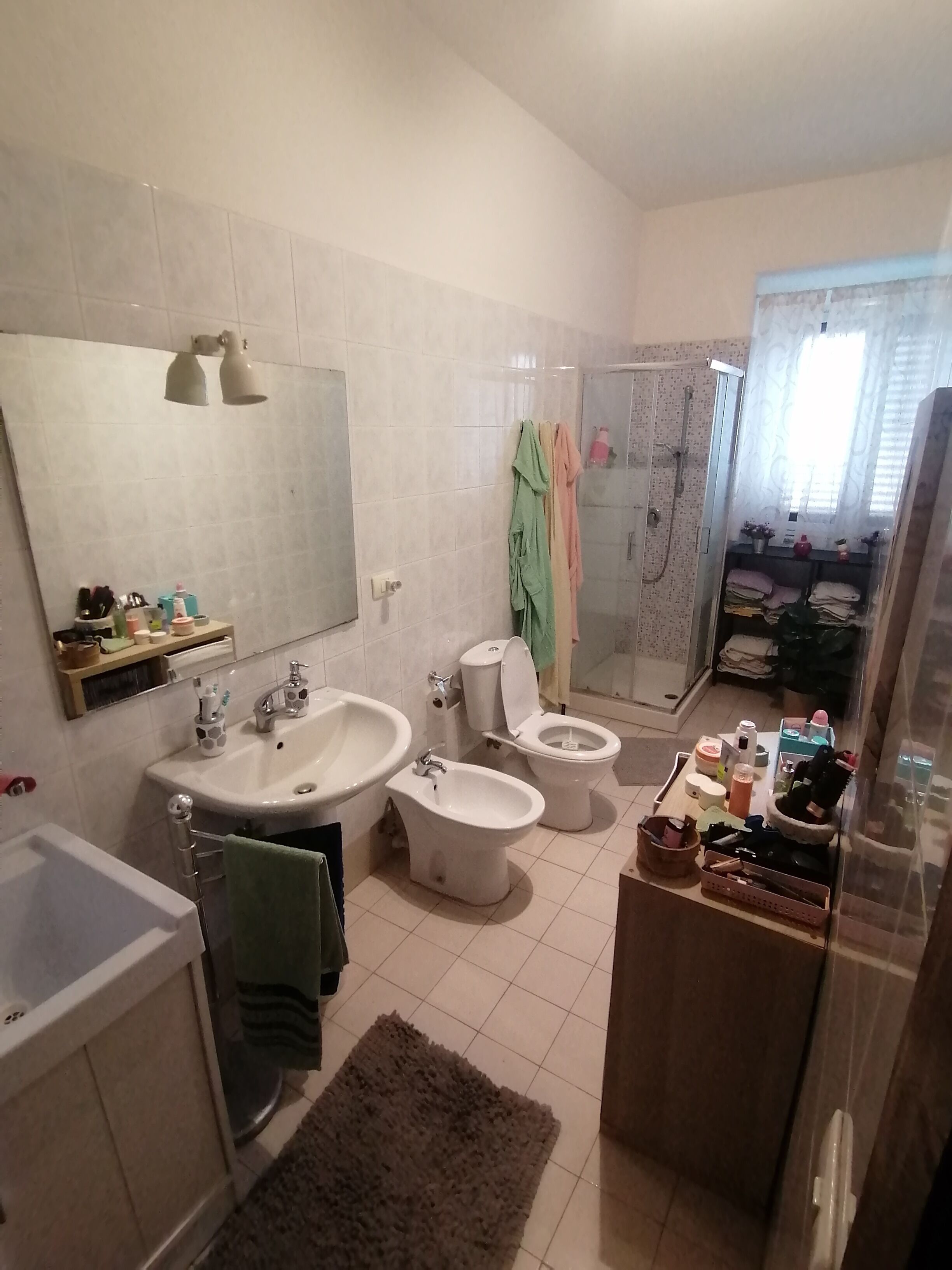 A bathroom with a bathtub, a sink, a bidet, a toilet, and a shower.