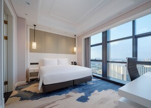 Ein modernes Hotelzimmer mit einem großen Bett, einem Nachttisch und einem Schreibtisch.