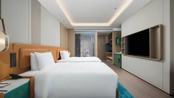 A modern hotel room with two beds, a TV, a bathroom, and a walk-in closet.