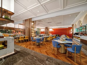 Ein modernes Restaurant mit Holzboden, Marmorarbeitsplatten und blauen Stühlen.