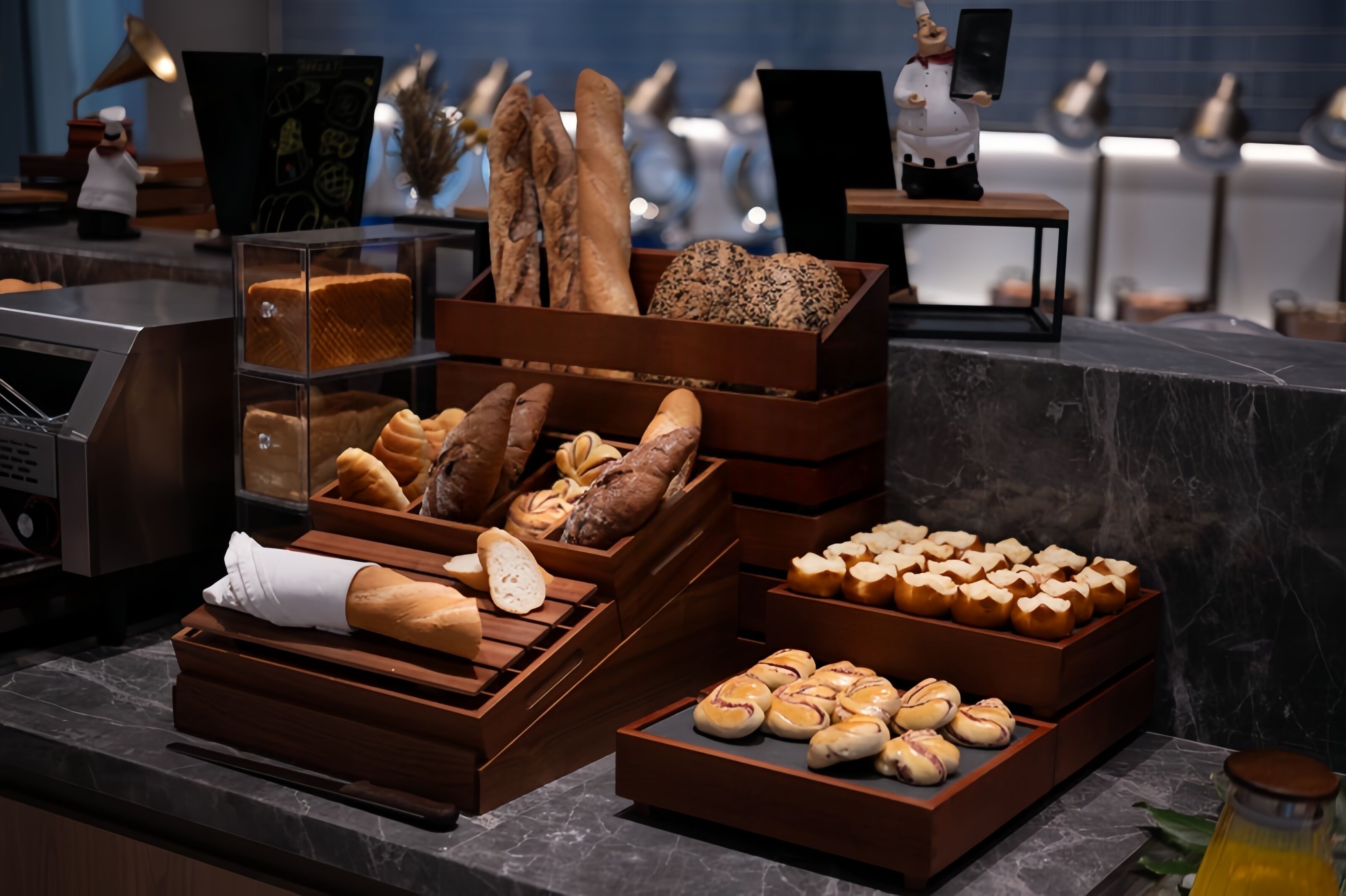 A bakery display with various breads and pastries in wooden boxes.