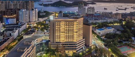A high-rise hotel with multiple floors, a prominent tower, and a waterfront view.