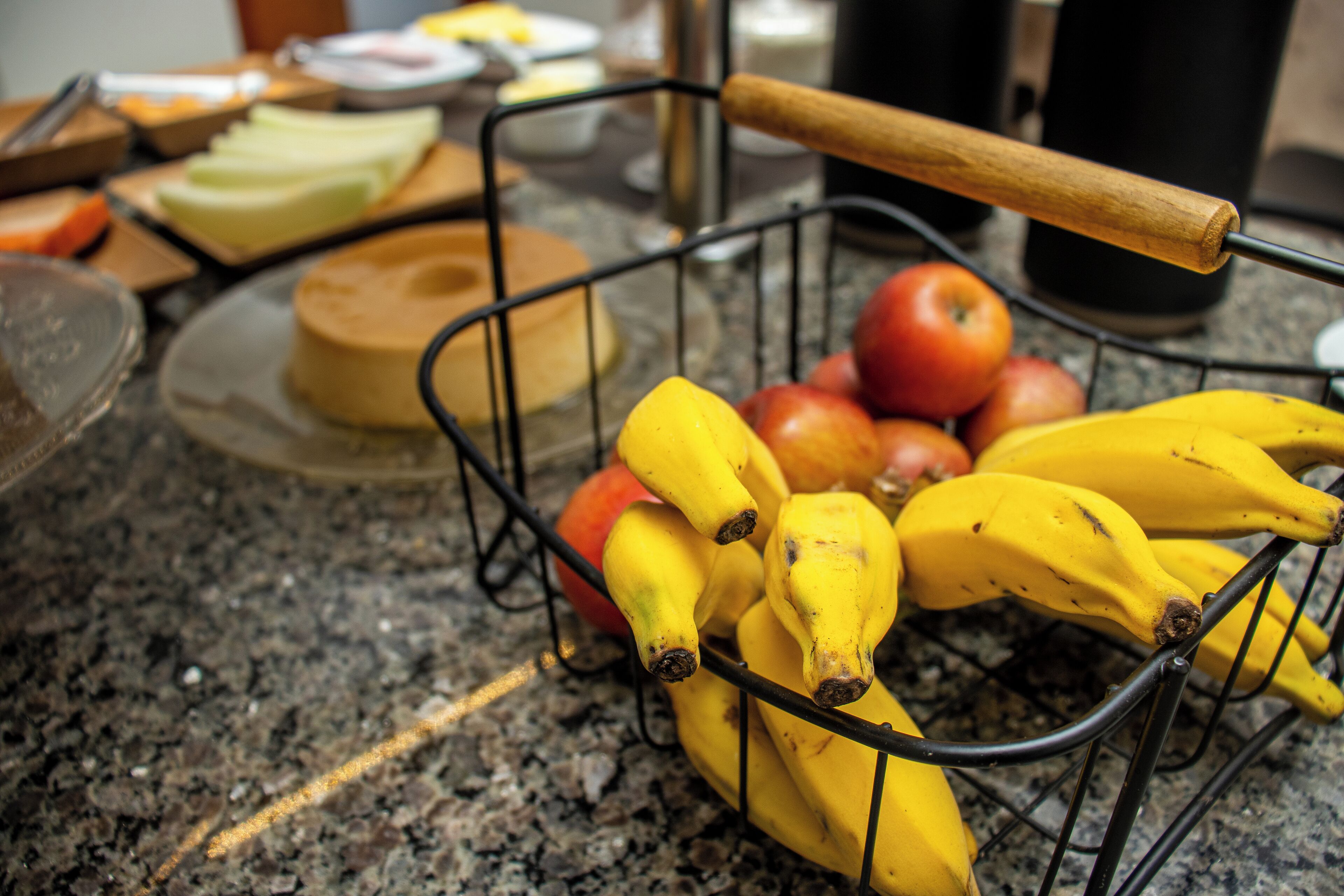 Eine Küchenarbeitsplatte mit einer Obstschale, die Bananen und Äpfel enthält.