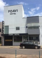 Un edificio moderno con un cartel que dice "FOAVI HOTEL" y una entrada de garaje.