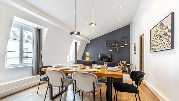A modern dining area with a wooden table set for four, surrounded by chairs. - ICONIC LANDMARKS THE LOUVRE MUSEUM ,TUILERIES GARDEN ARE JUST A STROLL AWAY (Paris)