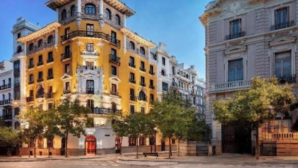 A historic building with a yellow facade, multiple balconies, and a central entrance with a red door. - Bright & Spacious 3-Bedroom Apartment in the Heart of Madrid (Madrid)